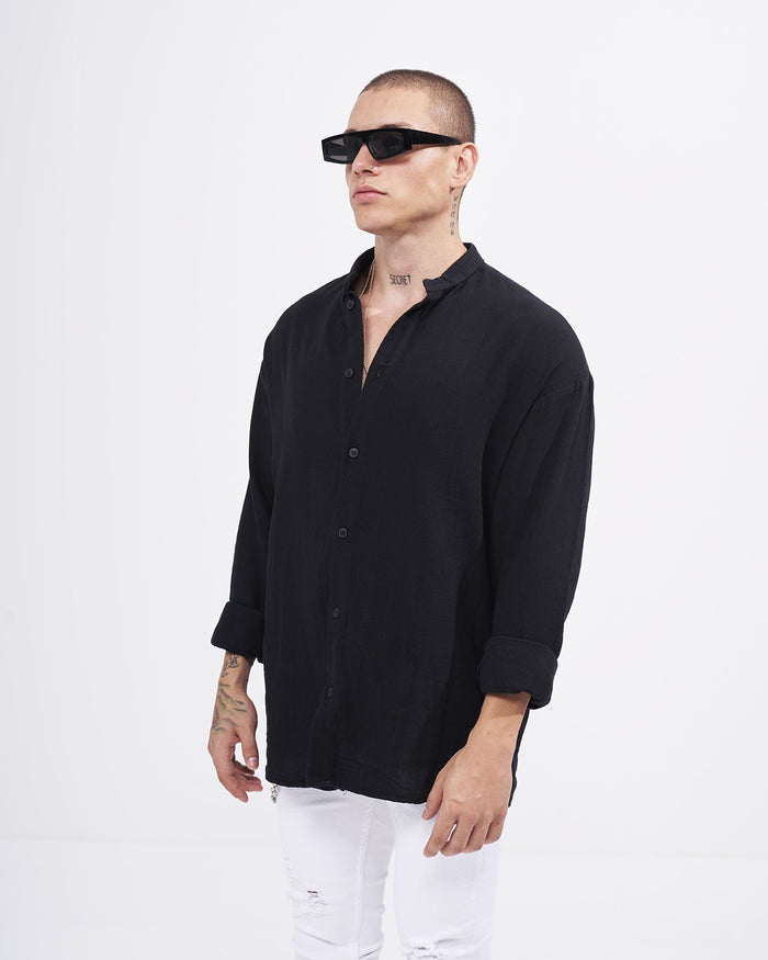 Martin Valen men’s oversized black linen mandarin-collar shirt, three-quarter view on model wearing sunglasses, collar open