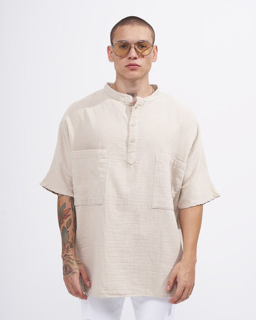 Martin Valen oversized beige linen shirt, front mid-body view with mandarin collar, half-button placket and patch pockets