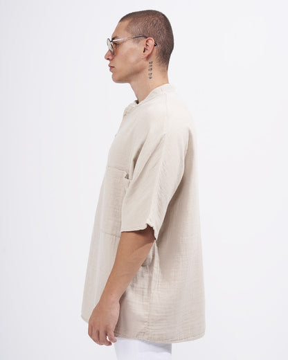 Martin Valen oversized beige linen half-button shirt with mandarin collar, side profile showing chest pocket