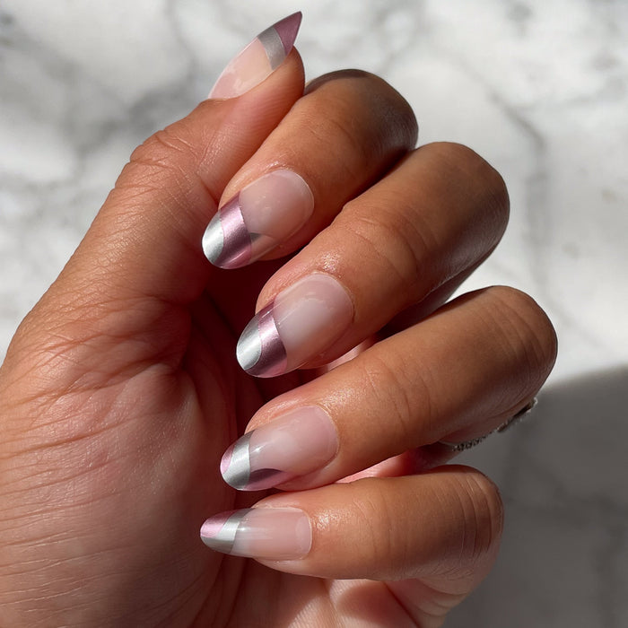 Metallic Swirls - Press-On | Medium | Oval nails with two-tone metallic pink and silver swirl in natural light on medium skin tone hand