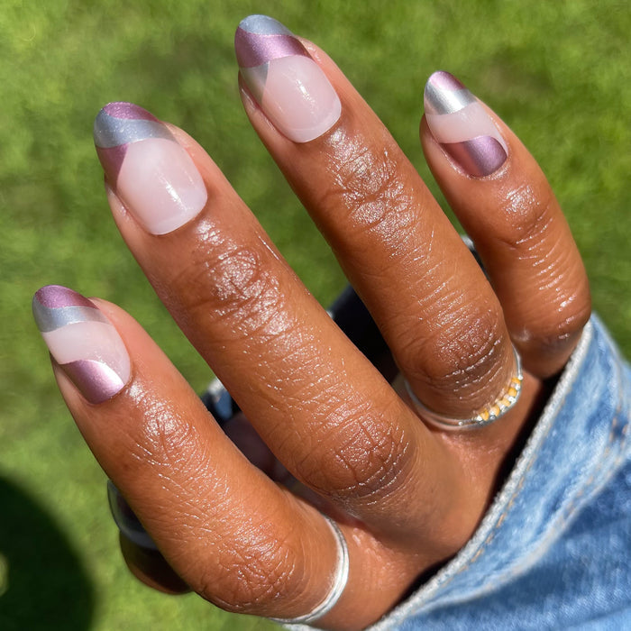 Metallic Swirls - Press-On | Medium | Oval false nails with two-tone metallic pink and silver swirl on medium skin tone hand outdoors