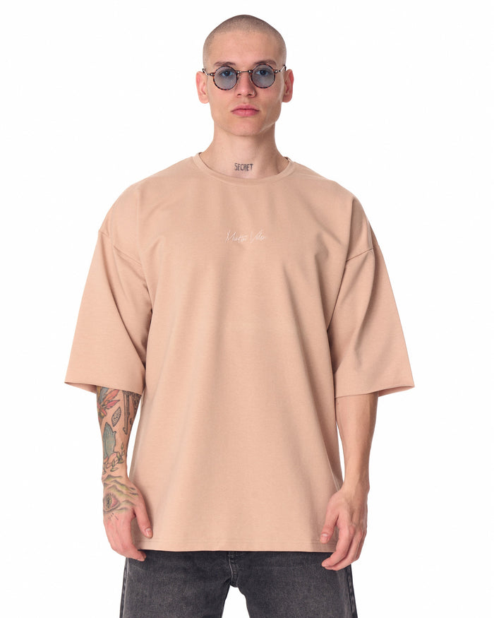Martin Valen oversized beige T‑shirt with small chest print, front close-up view showing round neckline and short sleeves