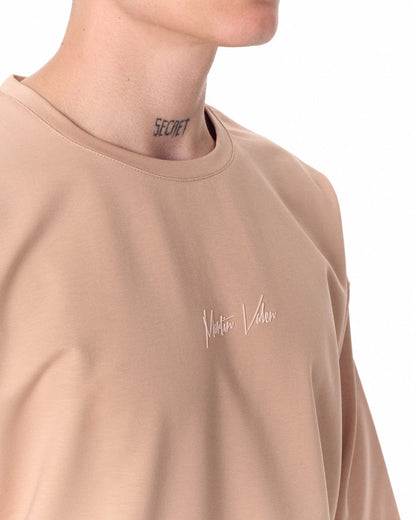 Martin Valen oversized beige T‑shirt close-up, crew neck with minimalist chest print visible