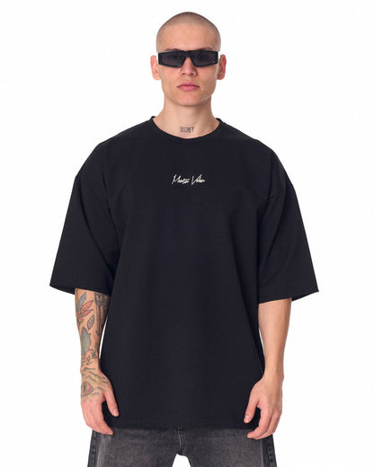 Martin Valen oversized black chest-printed T-shirt, front view worn by model with sunglasses and crew neckline