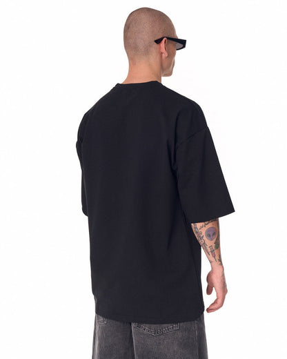 Martin Valen oversized black minimalist T-shirt seen from back, close-up on upper back and right shoulder