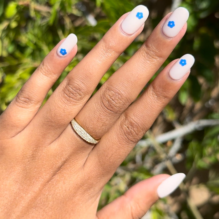 Mod Flowers | Short | Round - Tab Press-On nails with soft neutral polish and single modern blue flower detail on each nail outdoors