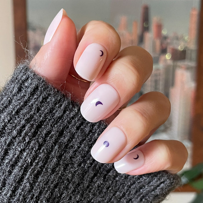 Moon Phases | Short | Squoval - Tab Press-On nails with soft neutral base and small purple moon phase accents on hand