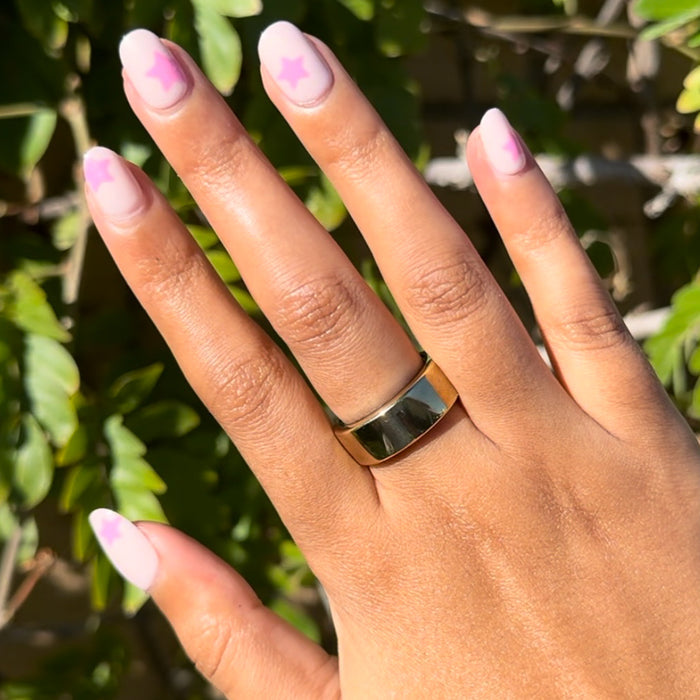 Pink Star Party | Extra Short | Round - Tab Press-On nails with tonal pink base and soft star design on hand outdoors