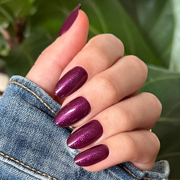 Plaza Shimmer | Medium | Oval - Tab Press-On nails in deep sparkly mulberry purple on natural medium oval-shaped nails
