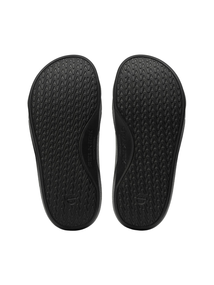 Black sandal soles with zigzag tread pattern, pair shown from bottom