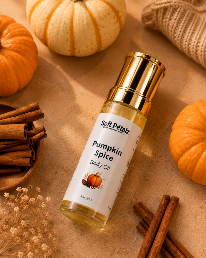 Pumpkin Spice body oil bottle with pumpkins, cinnamon sticks, and dried flowers on a brown background