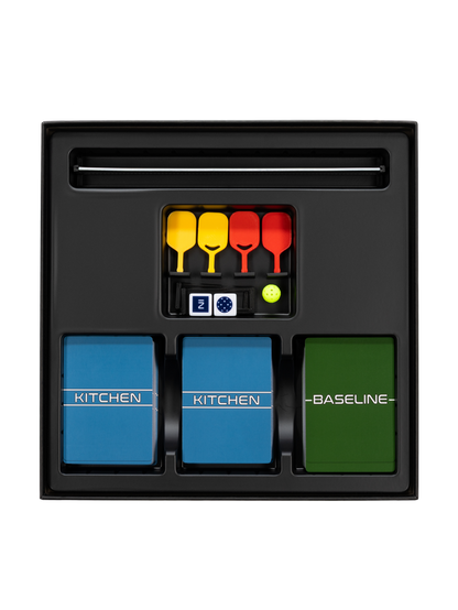 Game tray with two blue decks KITCHEN, green deck BASELINE, four yellow/red paddles, dice Z, and a green ball.