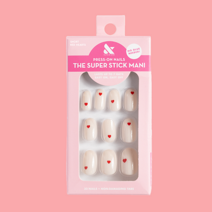 Red Hearts | Short | Round - Tab Press-On nails with neutral base and small red heart accents in pink packaging