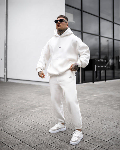 Martin Valen Regalia Crown oversized white hoodie and joggers, low-angle view with hood up and small crown logo