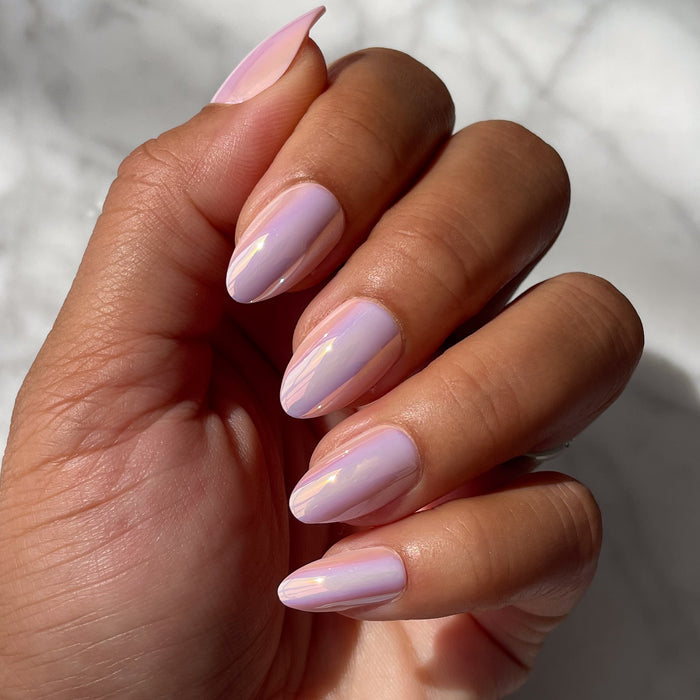 Hand with medium skin tone wearing Rose Chrome - Press-On | Medium | Almond nails in a shiny pink chrome mani under natural light