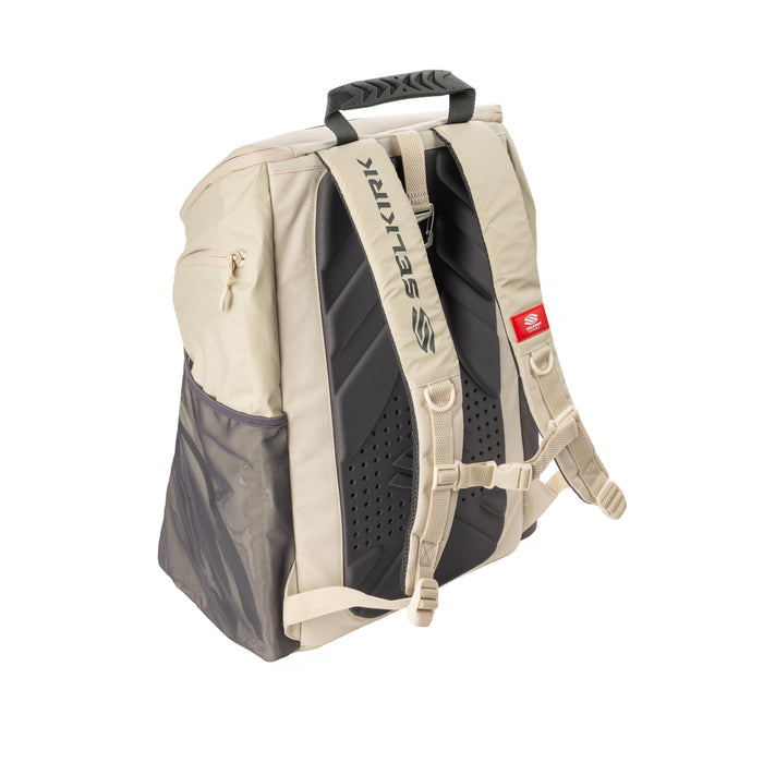 Beige-gray backpack rear with padded back panel, adjustable straps and top handle; SELKIRK on strap and red tag S