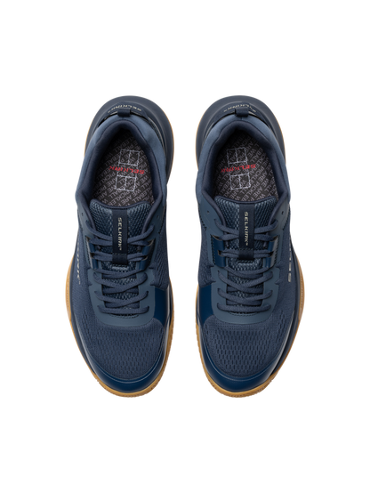 Top-down view of navy athletic sneakers with gum soles and patterned insoles.