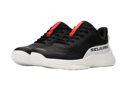 Black low-top athletic sneakers with white chunky sole and red tongue tab branded 'SELKIRK'.