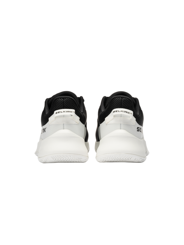 Rear view of a pair of black-and-white SELKIRK sneakers showing heel tabs with SELKIRK branding.