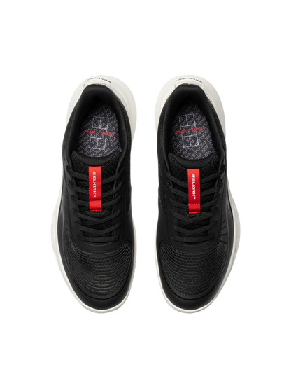 Top view of black athletic sneakers with red tongue labels reading 'Selkirk' and white midsoles.