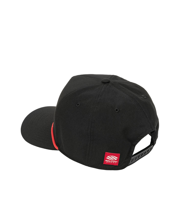 Black snapback cap, rear view showing adjustable plastic strap and small red rectangular brand tag at lower back