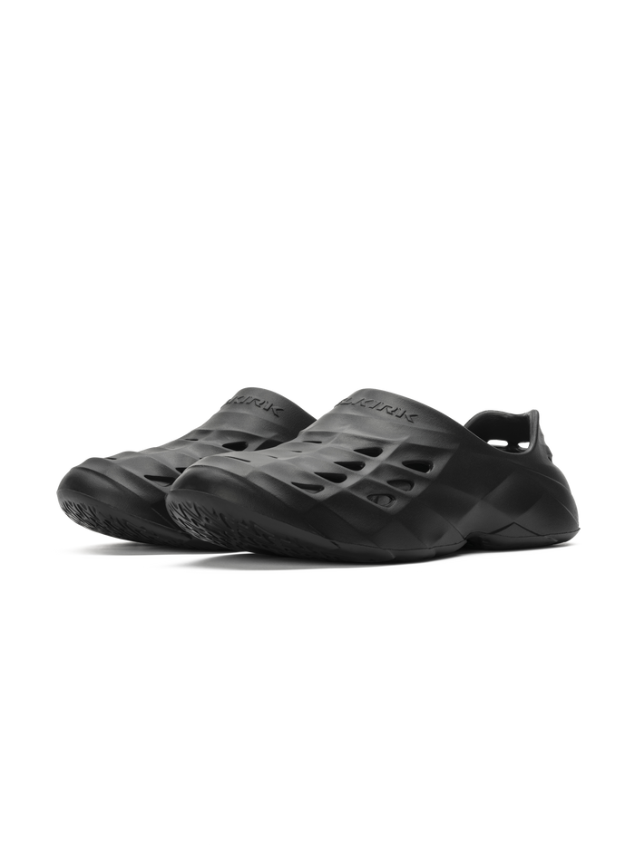 Pair of black slip-on foam clogs with sculpted vents and textured outsoles.