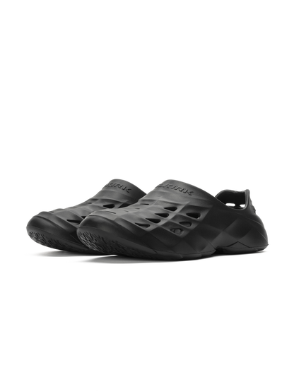 Pair of black slip-on foam clogs with sculpted vents and textured outsoles.