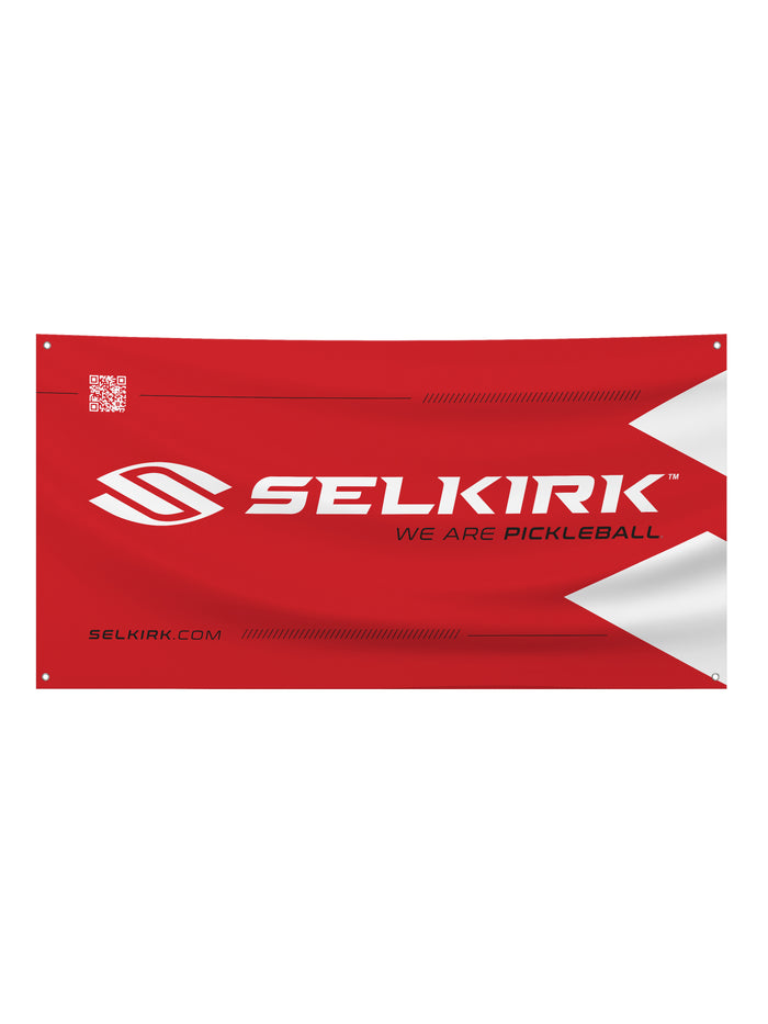 Red vinyl banner with large 'SELKIRK', tagline 'WE ARE PICKLEBALL', 'SELKIRK.COM' and white chevron accents