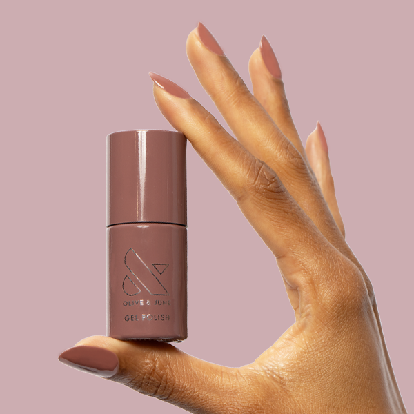 Shacket - Gel polish bottle held with warm rose neutral gel manicured nails by Olive and June