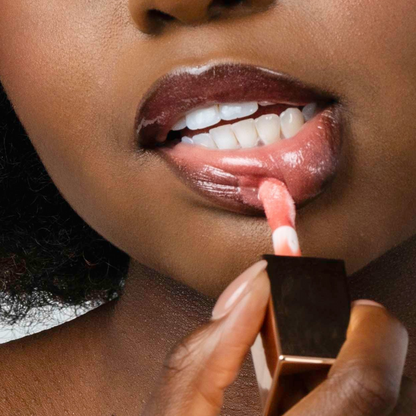 Close-up of Pink Lipps She’s All That Glow Lip Oil wand applicator showing glossy texture on black model