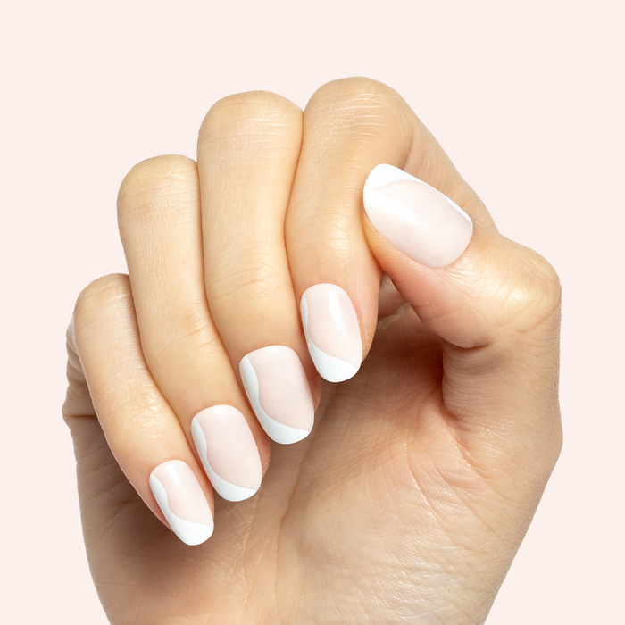 Side Swirl | Short | Round - Tab Press-On showing hand with neutral pink nails and subtle white swirl design on light background