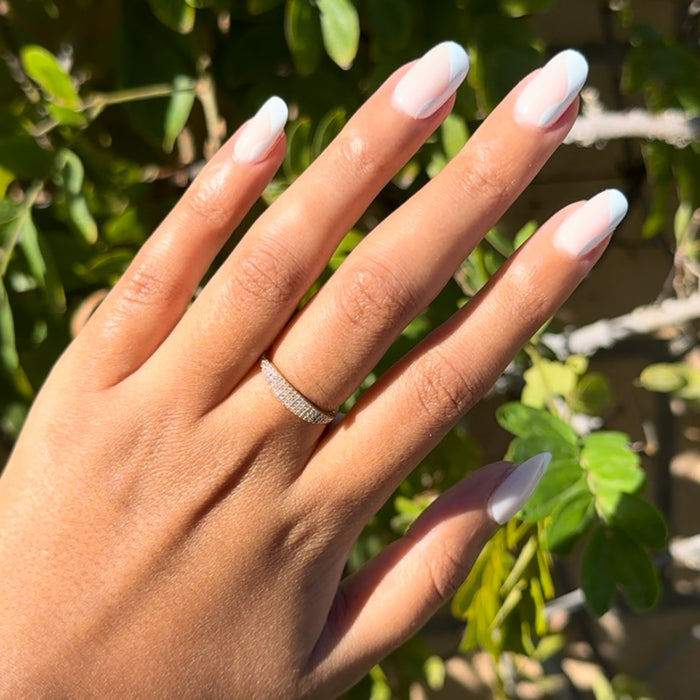 Side Swirl | Short | Round - Tab Press-On showing hand with white and neutral pink round false nails in natural sunlight outdoors