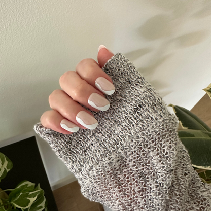 Side Swirl | Short | Round - Tab Press-On showing hand with neutral pink nails and pastel swirl design against knit sweater sleeve