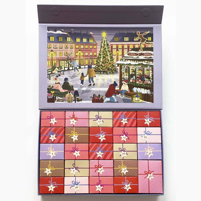 A beautifully illustrated winter scene of people gathered around a Christmas tree in a town square appears beneath the ViSSEVASSE Skate & Coffee Puzzle Advent Calendar—a festive set featuring 24 compartments to open, each revealing a section of the 1,000 piece jigsaw puzzle for daily discoveries, reminiscent of the wonder and anticipation of a classic holiday calendar.