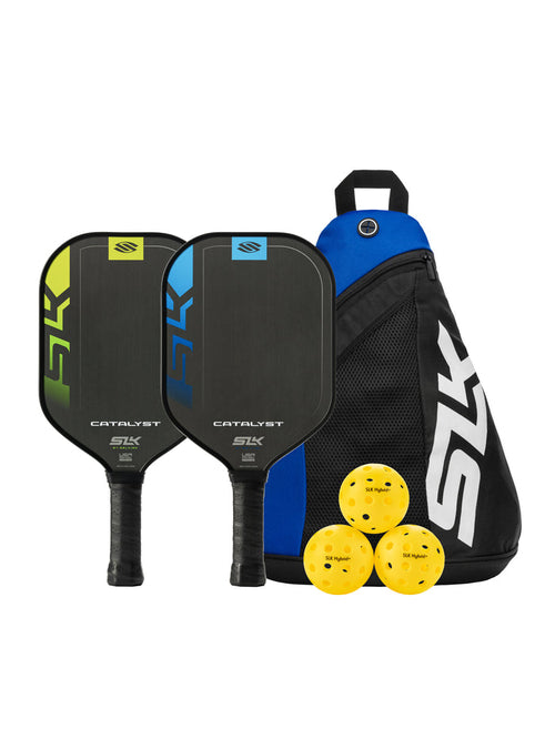 Two CATALYST pickleball paddles (SLK) with three yellow SLK Hybrid+ balls and a black-blue SLK backpack.
