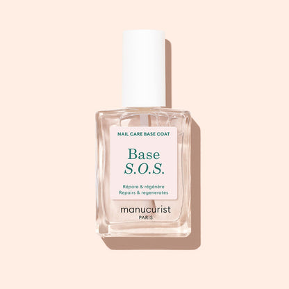 A clear Manucurist S.O.S. Nail Strengthener bottle with a white cap sits on a light beige background, featuring a label in French and English stating "Repairs  regenerates"—perfect for brittle nails needing repair.
