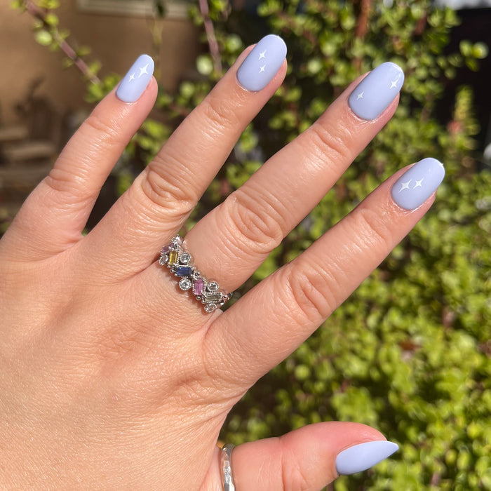 Sparkle Accent | Short | Round - Tab Press-On showing hand with light blue press-on nails and white sparkle details outdoors in sunlight