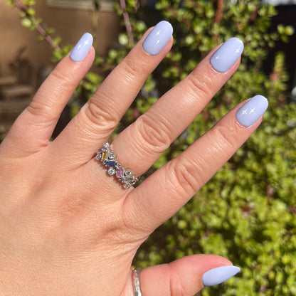 Sparkle Accent | Short | Round - Tab Press-On showing hand with light blue press-on nails and white sparkle details outdoors in sunlight