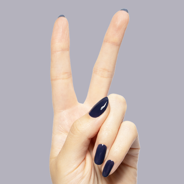 Suited - Gel dark navy glossy manicure on medium oval nails shown on hand against soft gray background