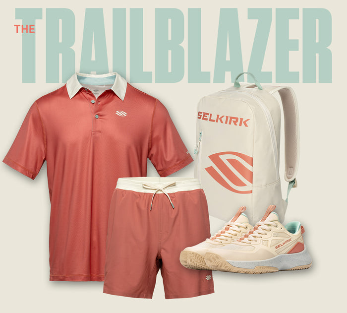 Selkirk "The Trailblazer" pickleball collection in a terracotta and cream palette, featuring a coral colorblock polo with a cream collar, matching coral shorts with a drawstring waist, a cream backpack with the Selkirk logo, and cream-and-coral court shoes with mint accents.