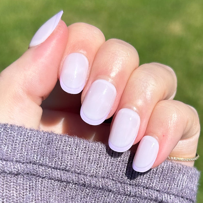 Tonal Lavender French | Extra Short | Round - Tab Press-On nails with subtle lavender French tips in natural light on hand outdoors