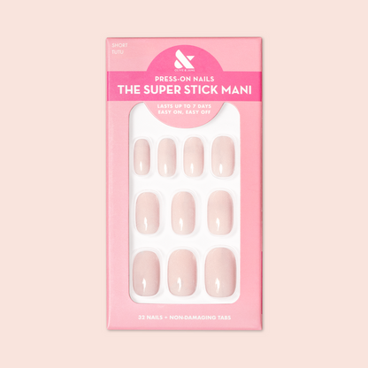 Tutu | Short | Squoval - Tab Press-On nails in soft pastel pink shade displayed in branded packaging for at-home mani.