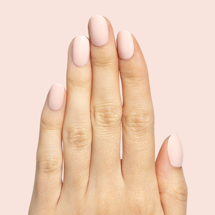 Tutu | Short | Squoval - Tab Press-On nails in soft pastel pink on hand against light pink background for easy mani application