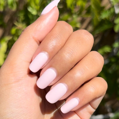 Tutu | Short | Squoval - Tab Press-On showing hand with pastel pink false nails outdoors in natural sunlight for easy mani.