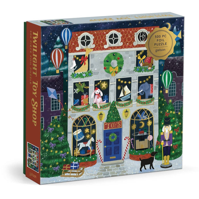 Enjoy a delightful puzzle experience with the Twilight Toy Shop | 500 Piece Jigsaw Puzzle from Galison, featuring a charmingly illustrated holiday toy shop adorned with wreaths, toys displayed in the windows, hot air balloons, a playful black cat, and festive decorations—perfect for anyone who loves whimsical puzzles.
