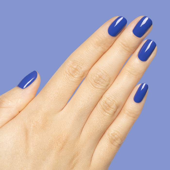 Hand with medium-length nails painted bright blue Your Mani Looks So Good in Those Jeans - Gel manicure