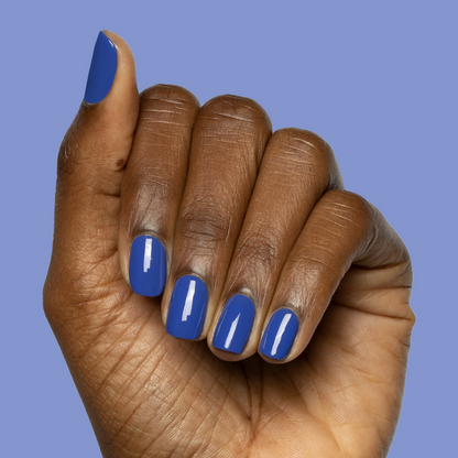 Hand with short nails polished in bright denim blue showing Your Mani Looks So Good in Those Jeans - Gel manicure